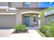Close-up of the home's entrance, showing a blue front door, tidy landscaping, and manicured lawn at 10360 Blue Plume Ct, Riverview, FL 33578
