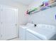 Functional laundry room with a washer, dryer, and convenient storage shelves at 10360 Blue Plume Ct, Riverview, FL 33578