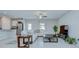 Open-concept living room with tile floors, ceiling fan, and an L-shaped white sofa at 10360 Blue Plume Ct, Riverview, FL 33578