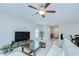 Spacious living room features tile floors, a ceiling fan, and a TV at 10360 Blue Plume Ct, Riverview, FL 33578