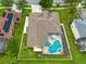 Aerial view of a home with a screened-in pool and spa overlooking a lush green yard at 10532 Plantation Bay Dr, Tampa, FL 33647