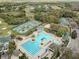 Aerial view of community pool, tennis courts, and clubhouse surrounded by trees and landscape at 10532 Plantation Bay Dr, Tampa, FL 33647