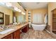 Luxurious bathroom boasts a soaking tub, dual sinks with granite countertops, and a separate shower at 10532 Plantation Bay Dr, Tampa, FL 33647