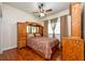 Bedroom with dark wood flooring, ceiling fan, and a built-in headboard with storage at 10532 Plantation Bay Dr, Tampa, FL 33647