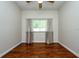 Well-lit bedroom with hardwood floors, neutral walls, ceiling fan, and large window with curtains at 10532 Plantation Bay Dr, Tampa, FL 33647