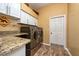 Laundry room with modern washer and dryer, granite countertops, and storage cabinets at 10532 Plantation Bay Dr, Tampa, FL 33647
