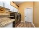 Laundry room with granite counters, utility sink, cabinets, and a gray washer and dryer at 10532 Plantation Bay Dr, Tampa, FL 33647