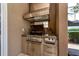 Outdoor kitchen featuring a built-in grill, vent hood, storage, and serving counter at 10532 Plantation Bay Dr, Tampa, FL 33647