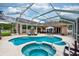 Captivating screened pool area featuring a spa and ample patio space, perfect for outdoor living at 10532 Plantation Bay Dr, Tampa, FL 33647