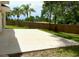 Spacious concrete patio surrounded by green grass and palm trees, ideal for outdoor gatherings at 10924 Summerton Dr, Riverview, FL 33579