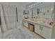 Bathroom featuring a long vanity with double sinks, a large mirror with vanity lighting, and a soaking tub at 10924 Summerton Dr, Riverview, FL 33579