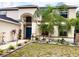 Inviting two-story home with well-manicured landscaping and a blue front door at 10924 Summerton Dr, Riverview, FL 33579