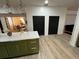 Open concept kitchen with hardwood floors, stainless steel appliances, and black doors at 10924 Summerton Dr, Riverview, FL 33579
