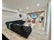 Spacious living room featuring hardwood floors and a luxurious black couch with gold accents at 10924 Summerton Dr, Riverview, FL 33579