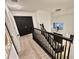 Upstairs hallway features wood railing, carpet, chandelier, and access to bedrooms at 10924 Summerton Dr, Riverview, FL 33579