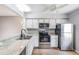 Galley kitchen featuring white cabinets, stainless steel appliances, and a granite countertop at 11511 113Th St # 22E, Largo, FL 33778