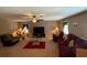 Open living room with carpet flooring, ceiling fan, comfortable seating, and a wall-mounted television for entertainment at 12231 Fairlawn Dr, Riverview, FL 33579