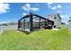 The backyard features a screened-in patio, perfect for outdoor gatherings and enjoying the green lawn at 12826 French Market Dr, Riverview, FL 33579