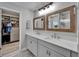 Beautiful bathroom featuring double vanity, framed mirrors, and a walk-in closet with custom shelving at 12826 French Market Dr, Riverview, FL 33579