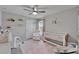 Adorable Bedroom with ceiling fan, pink rug, crib, and accent chair at 12826 French Market Dr, Riverview, FL 33579