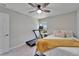 Bedroom view showcasing a treadmill by the window and a comfortable bed with a simple, clean aesthetic at 12826 French Market Dr, Riverview, FL 33579