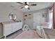 Comfortable Bedroom featuring a white crib, dresser, rocking chair, and decor at 12826 French Market Dr, Riverview, FL 33579