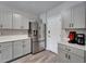 Well-equipped kitchen featuring stainless steel refrigerator, gray cabinetry, and quartz countertops at 12826 French Market Dr, Riverview, FL 33579
