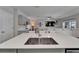 Kitchen island with stainless steel sink and modern faucet, opening to living and dining areas at 12826 French Market Dr, Riverview, FL 33579