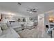 Spacious open-concept living room and kitchen features a large sectional sofa, ceiling fan, and modern decor at 12826 French Market Dr, Riverview, FL 33579