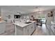 Open concept living space with kitchen island, dining area, and comfortable living room with backyard view at 12826 French Market Dr, Riverview, FL 33579