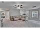 Upstairs loft featuring a ceiling fan, comfortable seating, and neutral decor with large windows at 12826 French Market Dr, Riverview, FL 33579