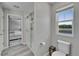 Well-lit main bathroom featuring a glass shower, toilet, and a view to the bedroom at 12826 French Market Dr, Riverview, FL 33579