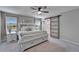 Bright main bedroom showcasing a bed with storage, dual windows, and a sliding barn door to the bathroom at 12826 French Market Dr, Riverview, FL 33579