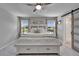 Bright main bedroom showcasing a bed with storage, dual windows, and a sliding barn door to the bathroom at 12826 French Market Dr, Riverview, FL 33579
