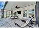 This stylish screened patio features a ceiling fan, a mounted TV, and elegant wicker furniture at 12826 French Market Dr, Riverview, FL 33579