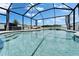 Beautiful screened-in pool area with ample seating, featuring a waterfall and serene outdoor living at 12826 French Market Dr, Riverview, FL 33579