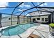 Luxurious screened-in pool area featuring ample seating and lush landscaping for a relaxing outdoor oasis at 12826 French Market Dr, Riverview, FL 33579