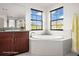 This elegant bathroom has a tub with granite countertops and decorative flower detail at 13299 Wildgrass Trl, Odessa, FL 33556