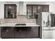 Kitchen with dark cabinets, a stylish backsplash, stainless steel appliances and quartz countertops at 13299 Wildgrass Trl, Odessa, FL 33556