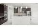 Bright kitchen with a large center island, dark cabinets, stainless steel appliances, and modern pendant lighting at 13299 Wildgrass Trl, Odessa, FL 33556