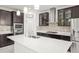 Spacious kitchen island with quartz countertop, pendant lights, and dark cabinets, complemented by stainless steel appliances at 13299 Wildgrass Trl, Odessa, FL 33556