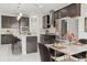 Modern kitchen featuring dark cabinets, a large island with seating, and stainless steel appliances at 13299 Wildgrass Trl, Odessa, FL 33556