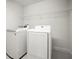 Bright laundry room equipped with new white washer and dryer units and a wire rack shelf at 13299 Wildgrass Trl, Odessa, FL 33556