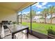 Screened-in patio with outdoor dining area overlooking a lush backyard and landscaping at 13299 Wildgrass Trl, Odessa, FL 33556