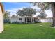 Wide back yard with mature trees, lawn, and a screened in patio at 1384 S Hillcrest Ave, Clearwater, FL 33756