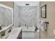 Bright bathroom featuring a jacuzzi tub, double vanity, and a modern lighting fixture at 1384 S Hillcrest Ave, Clearwater, FL 33756