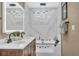 Modern bathroom featuring double sinks, jacuzzi tub, marble backsplash, and decorative lighting at 1384 S Hillcrest Ave, Clearwater, FL 33756