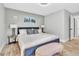 Bedroom featuring a blue bed with a cushioned bench and light hardwood floors at 1384 S Hillcrest Ave, Clearwater, FL 33756