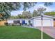 Cozy single-story home featuring a manicured lawn, blue front door, and attached garage at 1384 S Hillcrest Ave, Clearwater, FL 33756