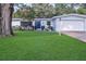 Charming single-story home with a well-manicured lawn and lush landscaping at 1384 S Hillcrest Ave, Clearwater, FL 33756